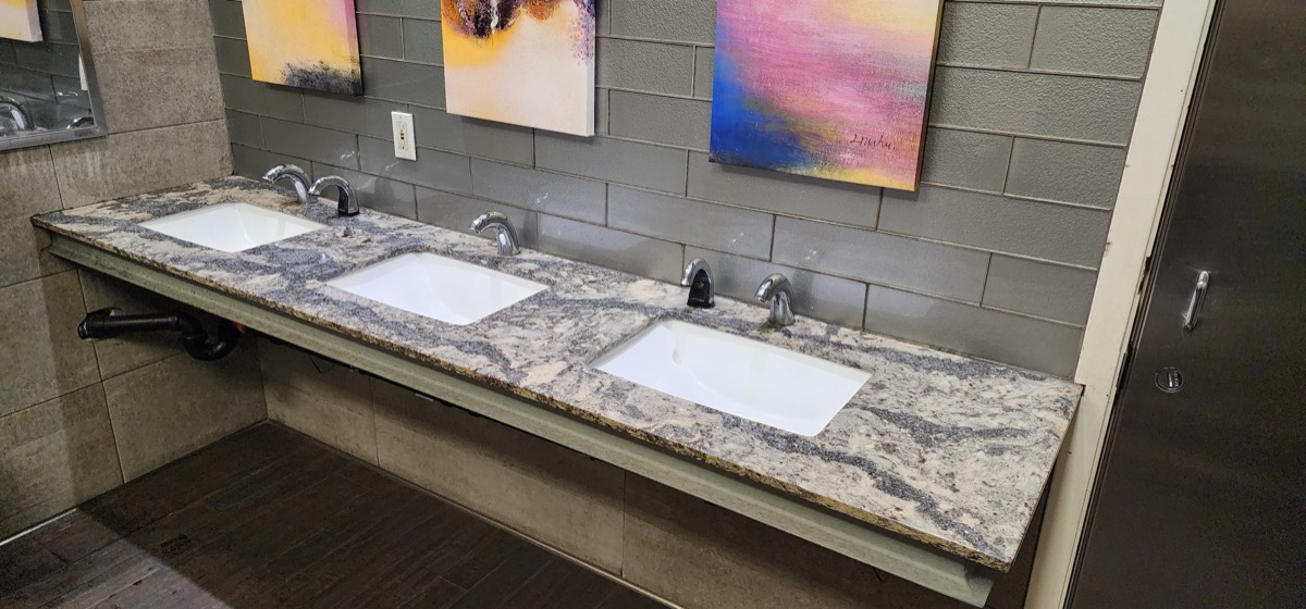 Custom triple vanity with granite countertop and chrome fixtures in Oakland bathroom remodel